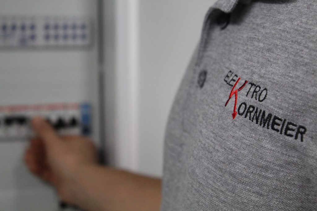Elektriker von Elektro Kornmeier arbeitet an der Verdrahtung eines Schaltschrankes bei einer Gebäudeinstallation